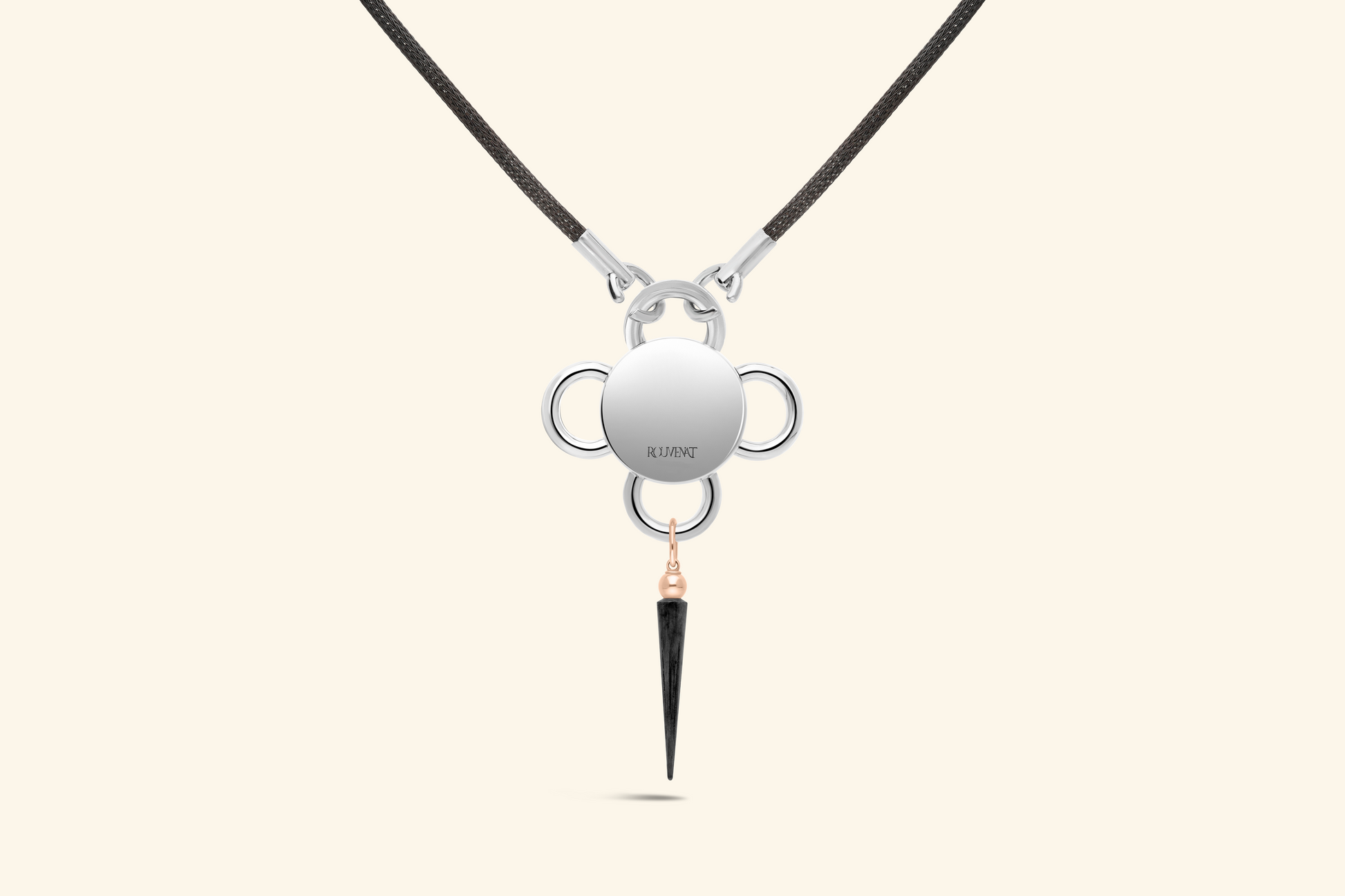Collier Bolt, émeraude de ~0,80 carat sertie une fleur en or rose poli, elle-même posée sur un plateau en argent satiné. Une pampille en or rose et argent noirci. Chaine tricotée en argent noirci.