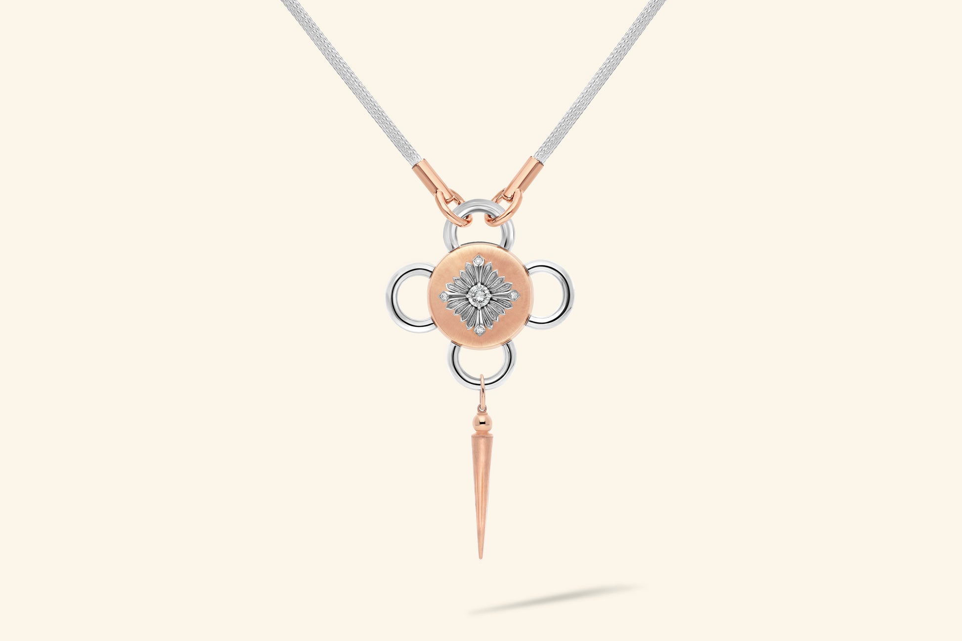 Collier Bolt, diamant de ~0,55 carat serti sur une fleur en argent poli, décorée de 4 diamants pour ~0,04 carat et posée sur un plateau en or rose satiné. Chaine tricotée en argent, manchons en or rose poli.
